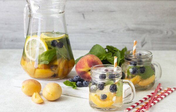 Fruta de estación junto a una jarra con agua